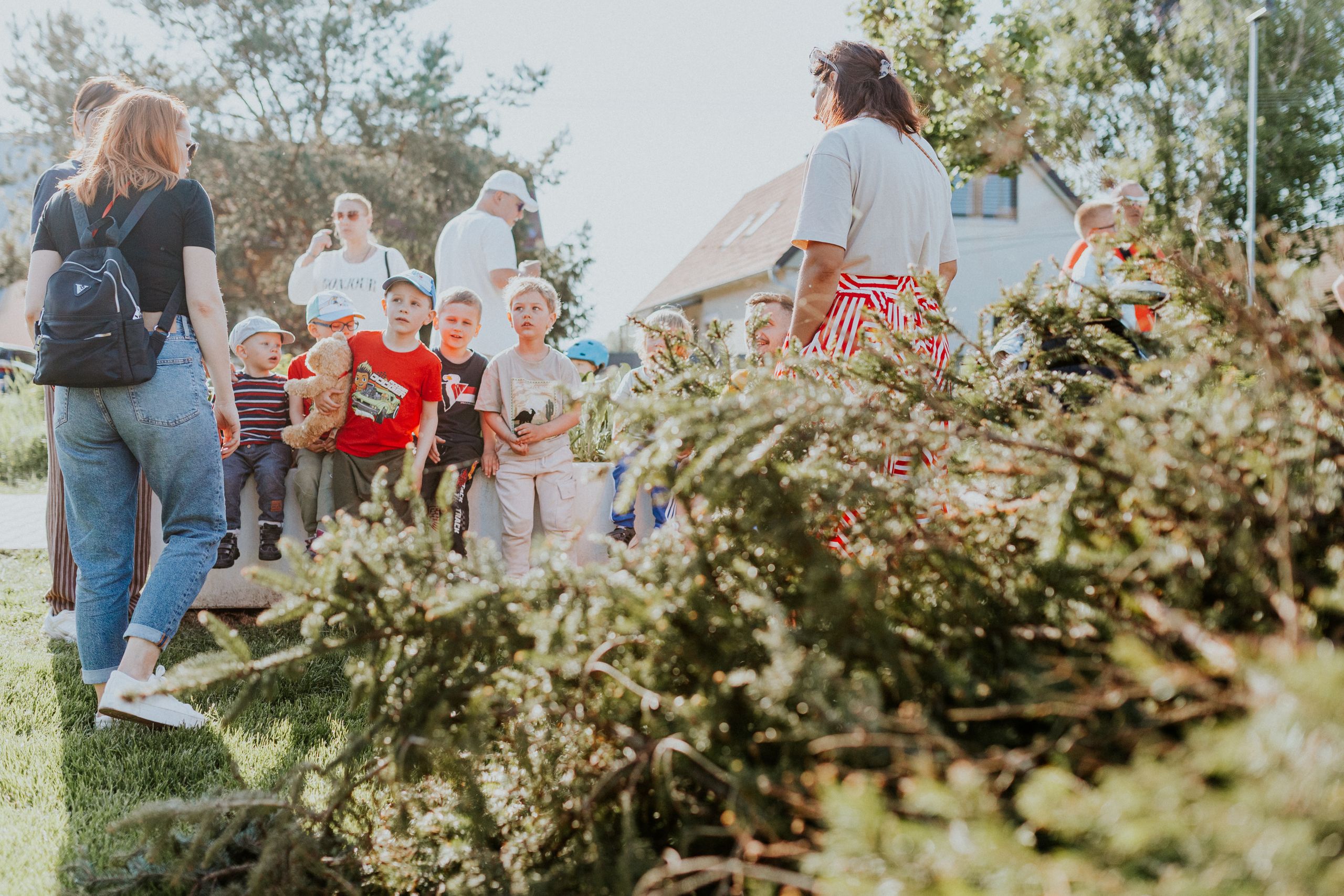 Wycieczki szkolne 4 Children and adults participating in an outdoor educational activity surrounded by nature.