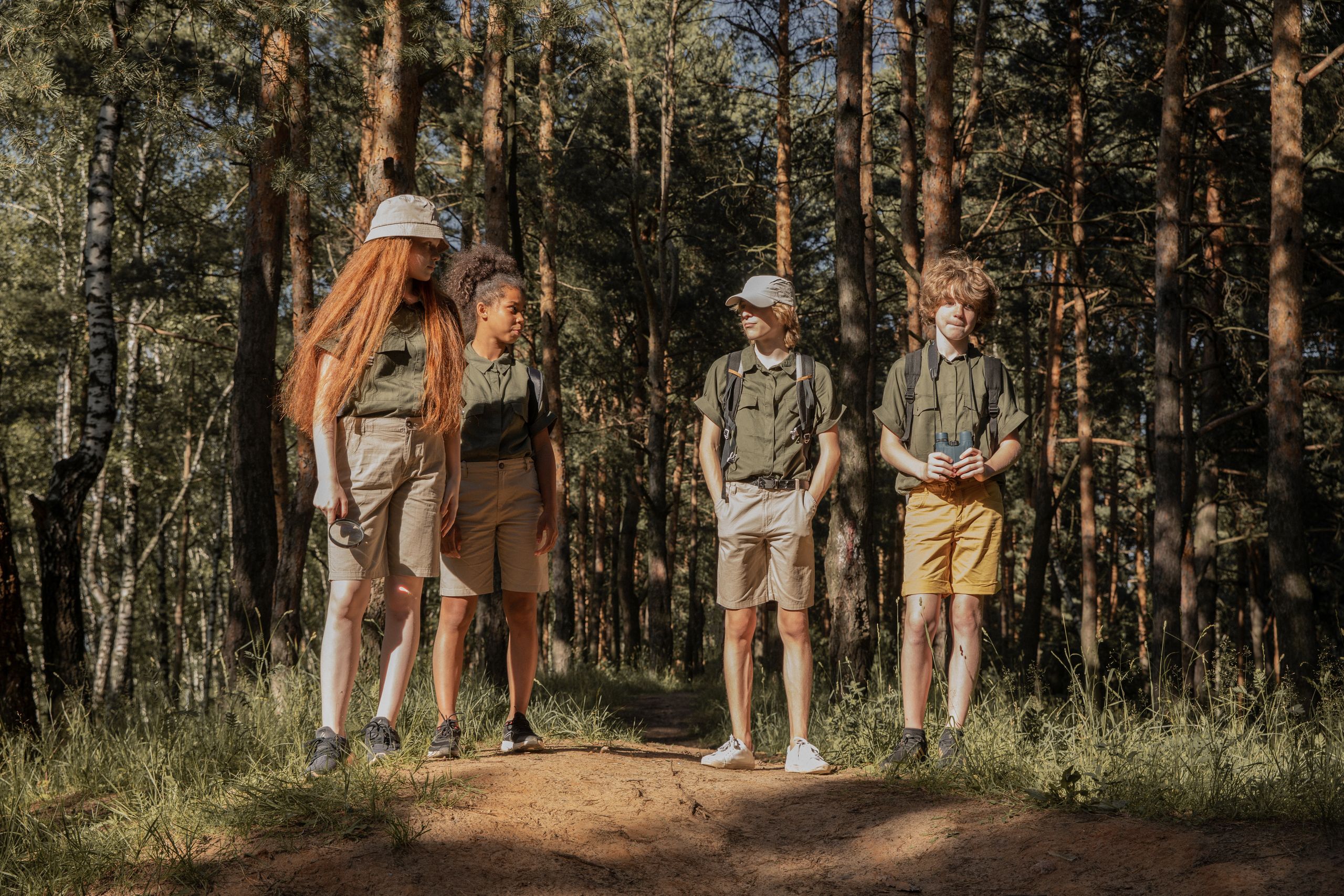 Wycieczki szkolne 2 Group of teenage scouts standing on a forest trail, enjoying a sunny adventure.