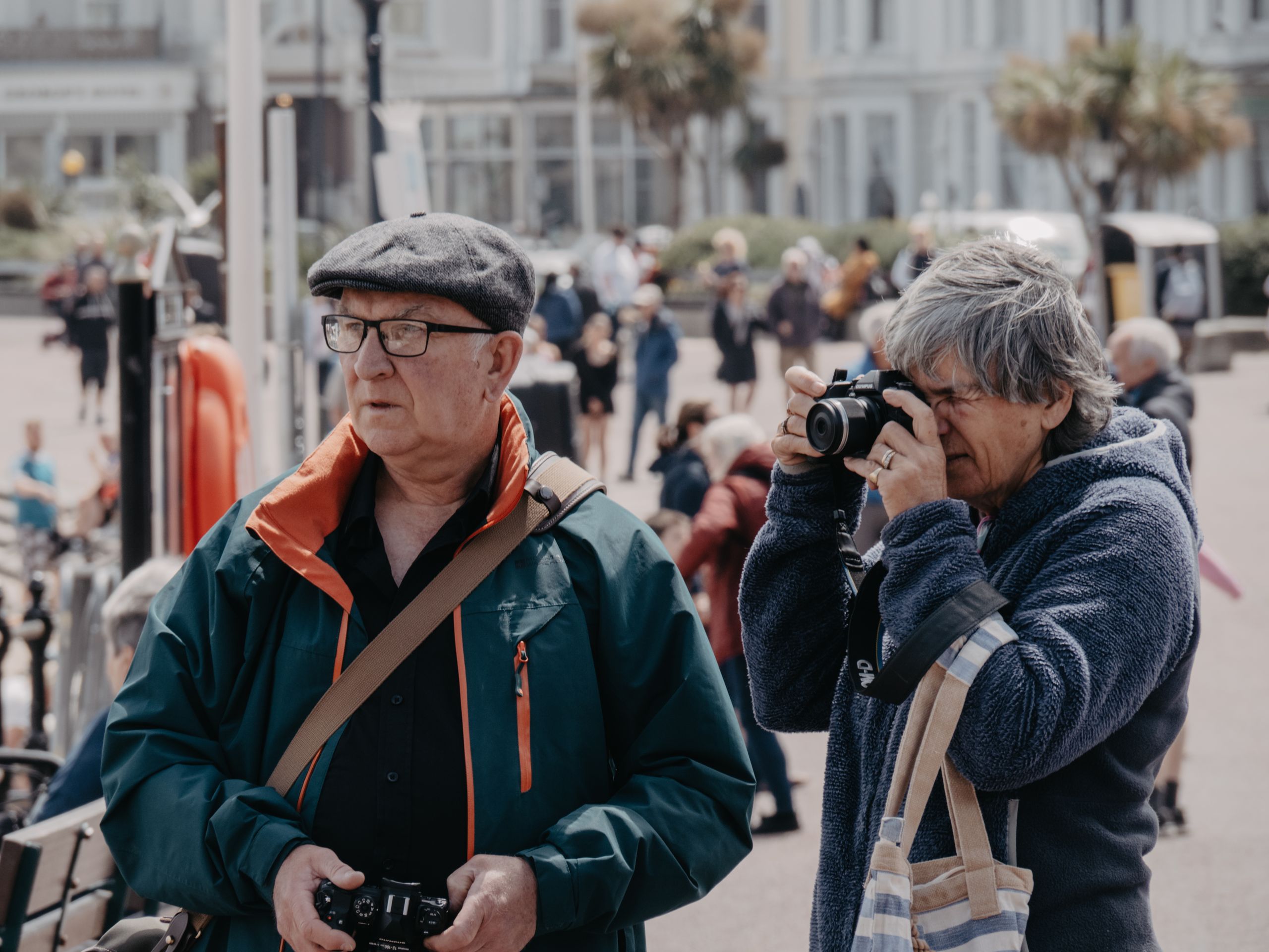 Oferty dla grup 7 Senior tourists capturing moments at a UK landmark, embracing travel and leisure.