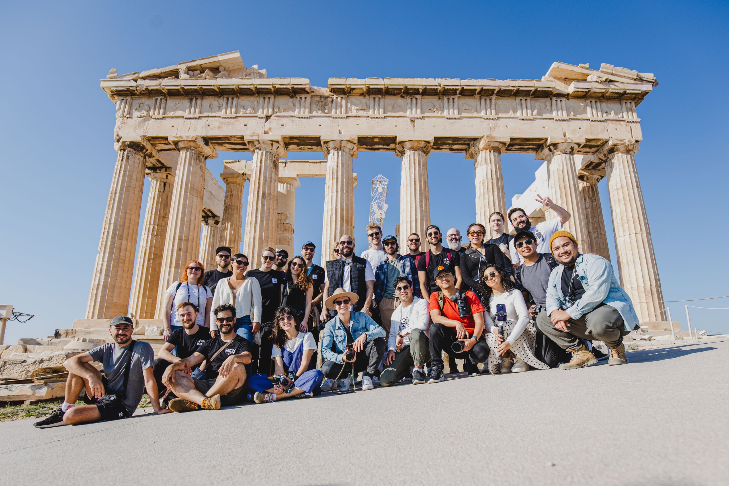 Wycieczki szkolne 5 A group photo of tourists in front of the Parthenon, Athens, Greece under a clear blue sky.