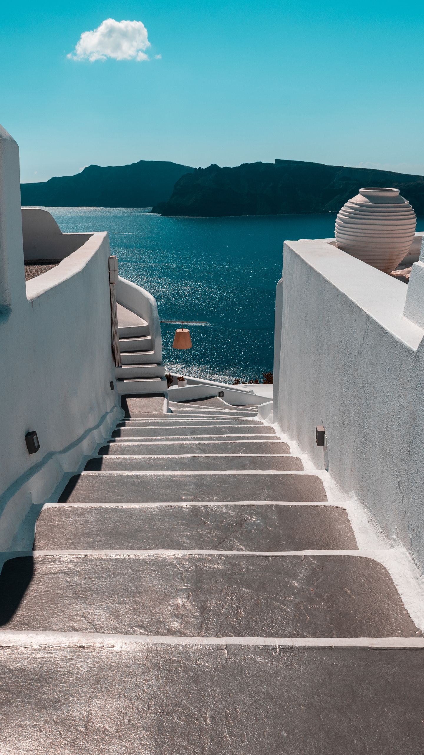Wczasy i Wycieczki 1 A stunning view of white steps leading to the Aegean Sea in Thera, Greece under a clear blue sky.